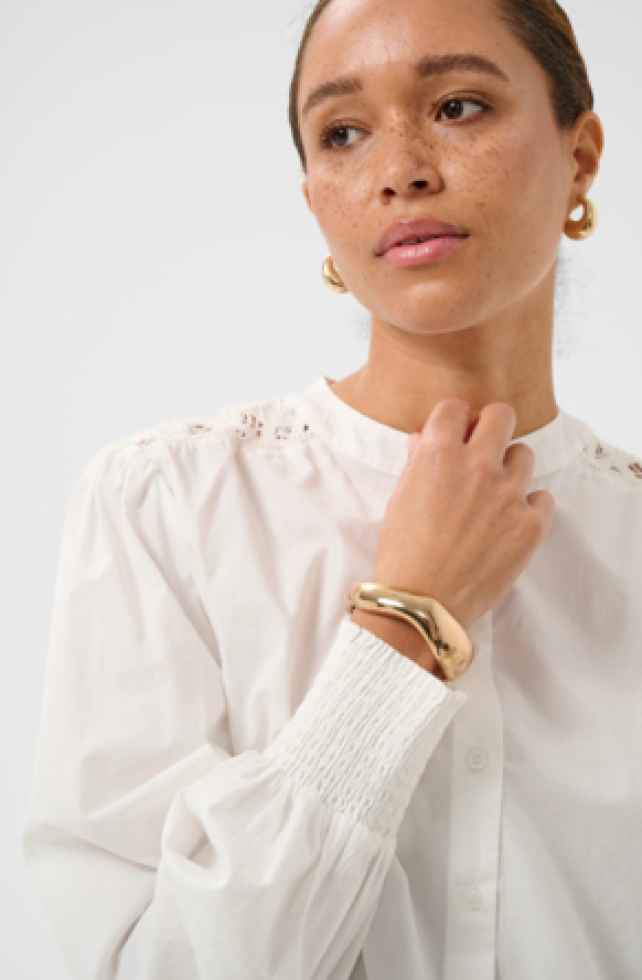 Bluse in offwhite mit kleinem Stehkragen und gesmoktem Ärmelabschluss sowie feminem Details auf der Rückseite Wunderwerk Oldenburg